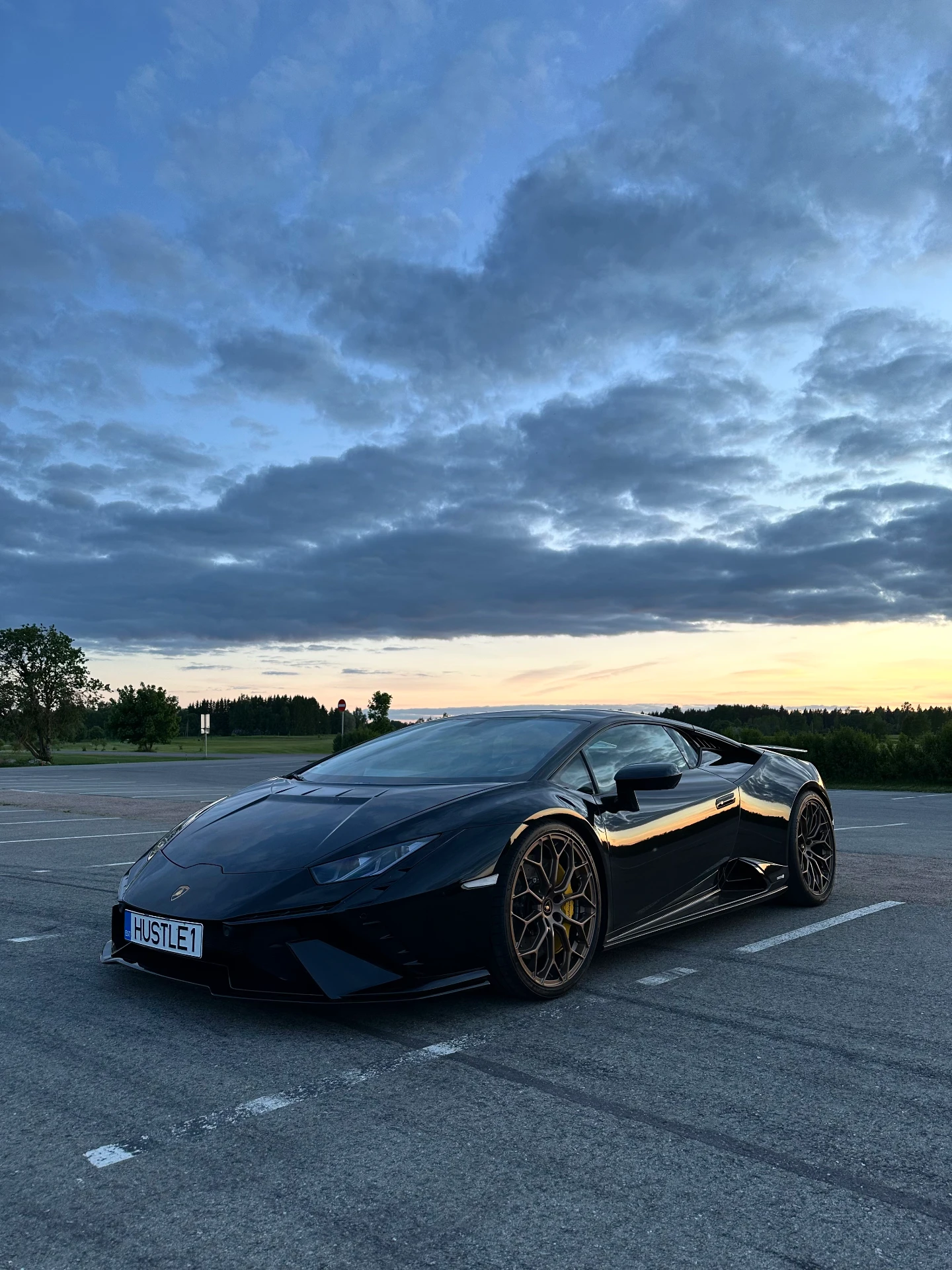 HSTLE — must Lamborghini Huracán numbrimärgiga HUSTLE1 päikeseloojangus